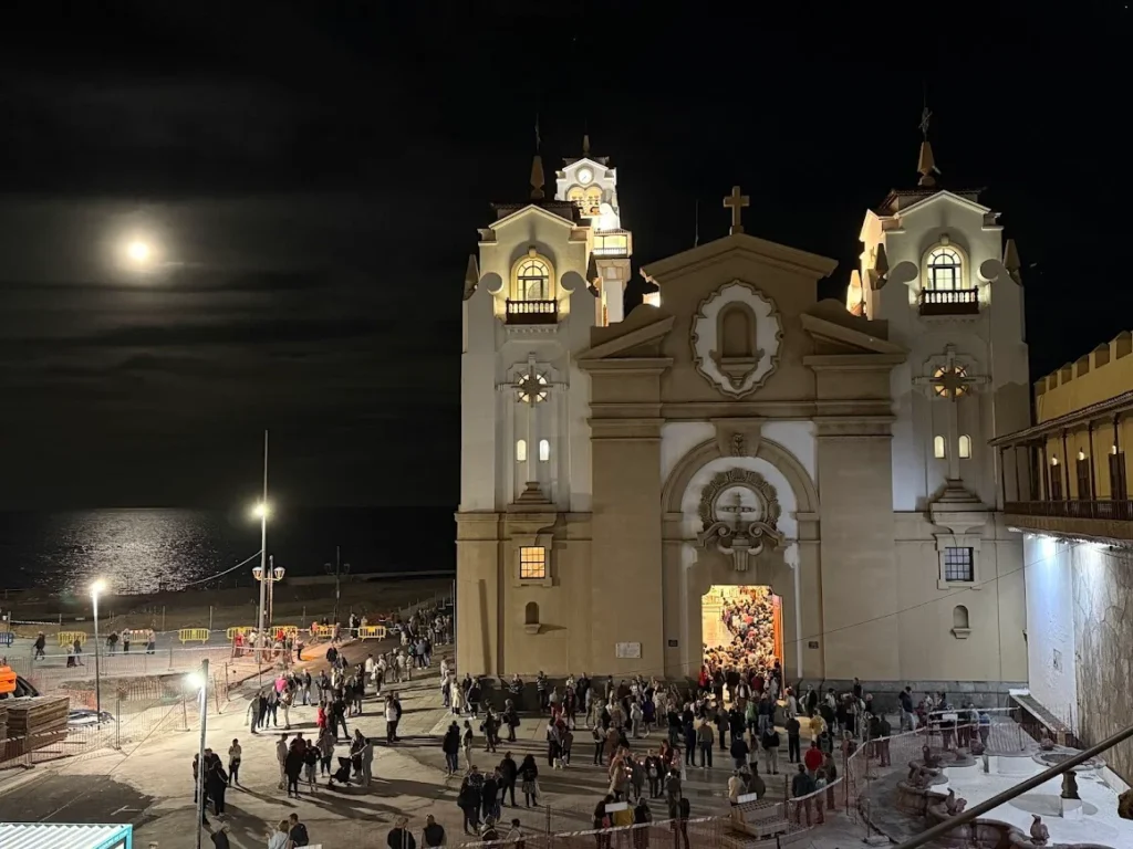 Basilica of Candelaria lit up at night during the procession with crowds filling the square, Tenerife