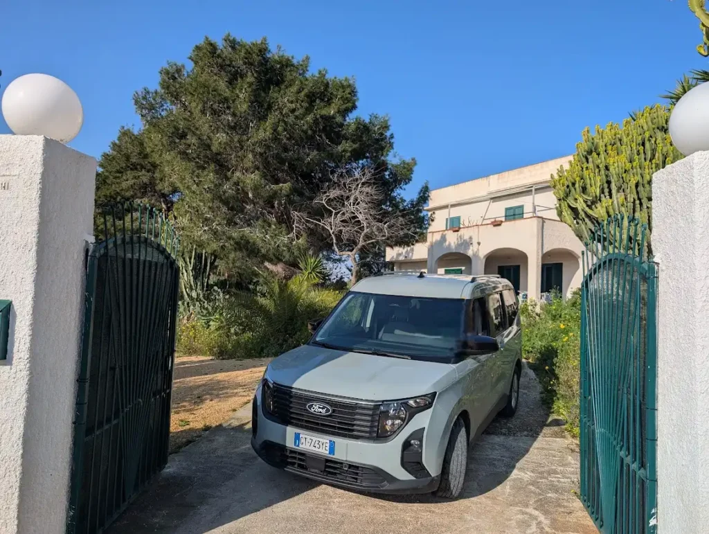 Ford Tourneo rental car parked in a private driveway outside a Sicilian villa