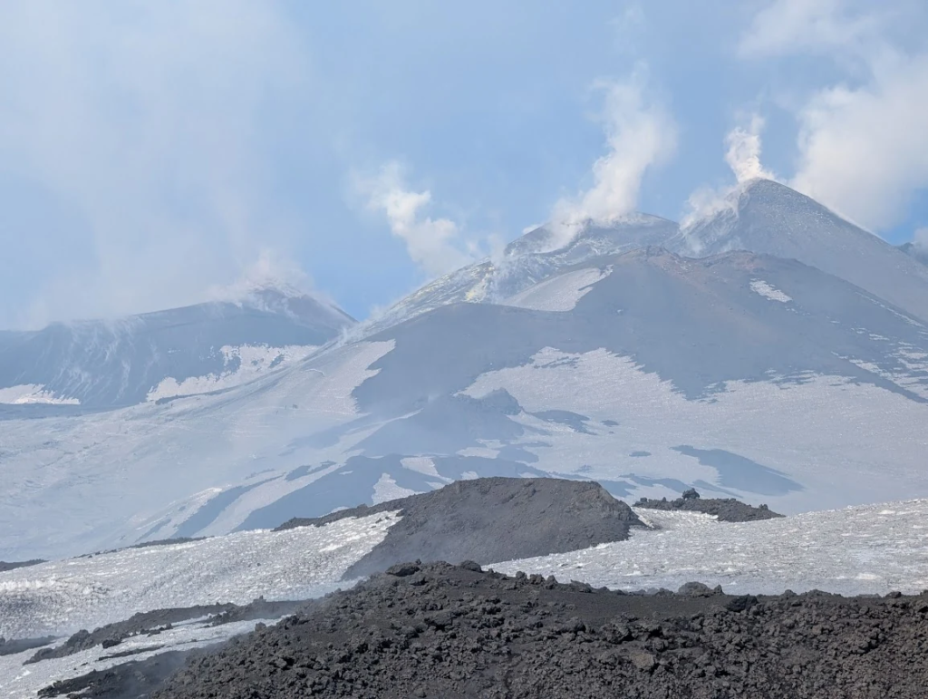 Mount Etna summit craters emitting steam and smoke during a daytime hike from Rifugio Sapienza, Sicily