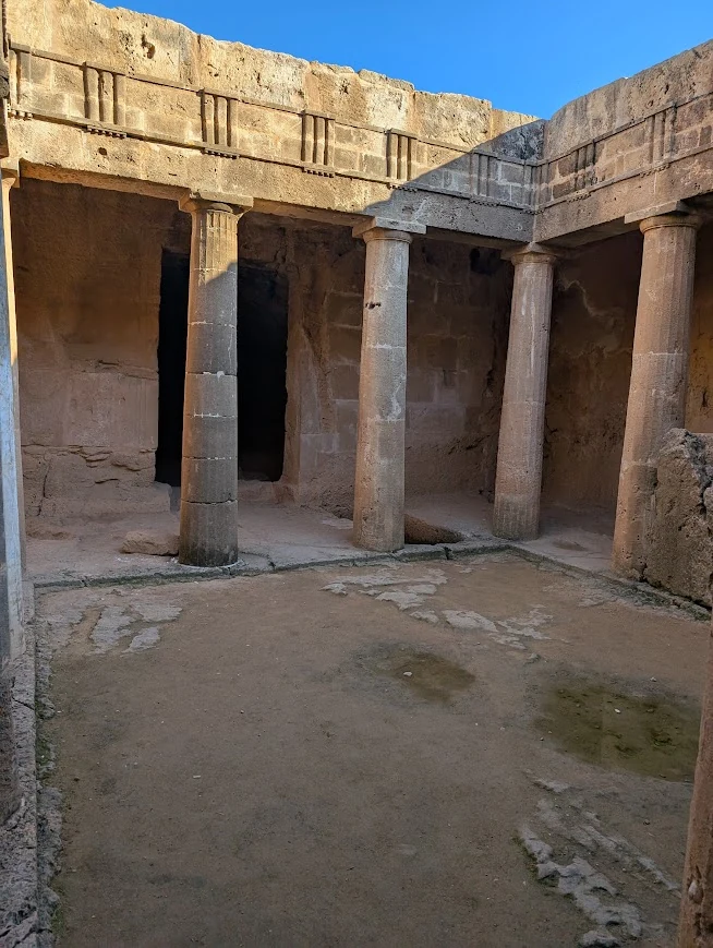 Underground burial chamber at the Tombs of the Kings archaeological site in Paphos, Cyprus, with stone columns and carved walls, January 2025.