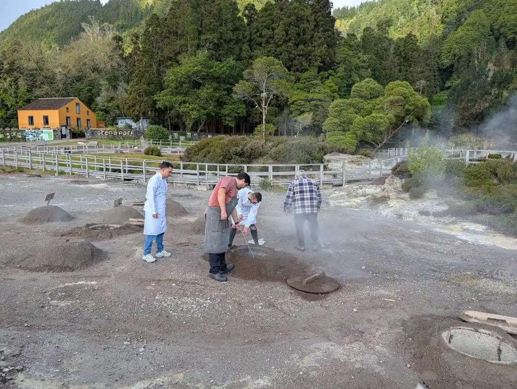 Workers digging up traditional cozido das Furnas from underground geothermal cooking pots, São Miguel, Azores