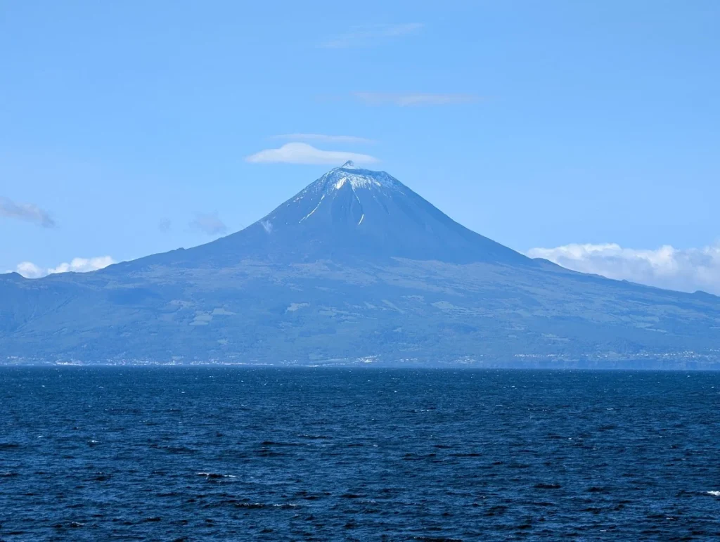 View of the snow-capped Mount Pico volcano in the Azores from the ferry across the Atlantic Ocean.