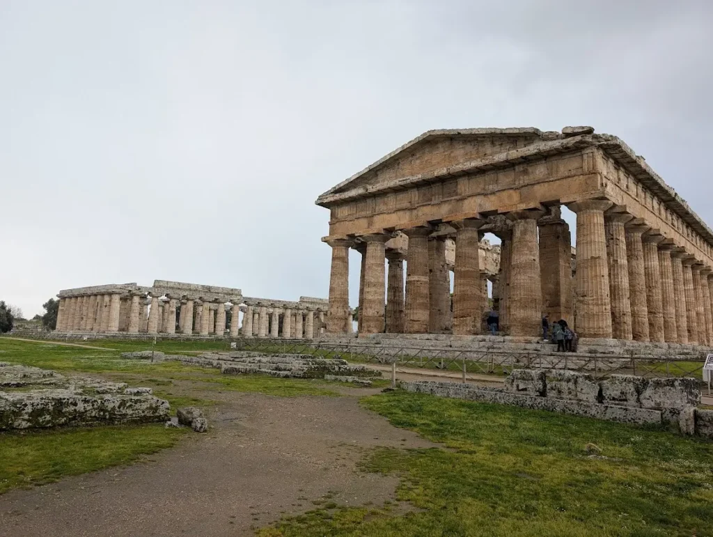 Two ancient Greek temples at Paestum standing in an open field, Campania, Italy