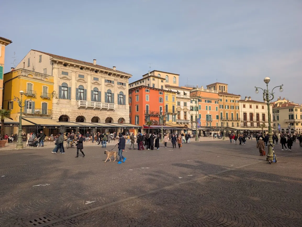Piazza Bra in Verona with colorful historic buildings and people walking