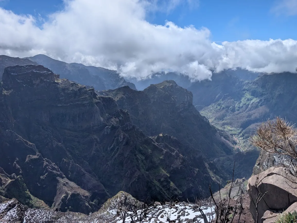 View from Pico Ruivo over Madeira's central mountains with snow patches and burnt trees in the foreground