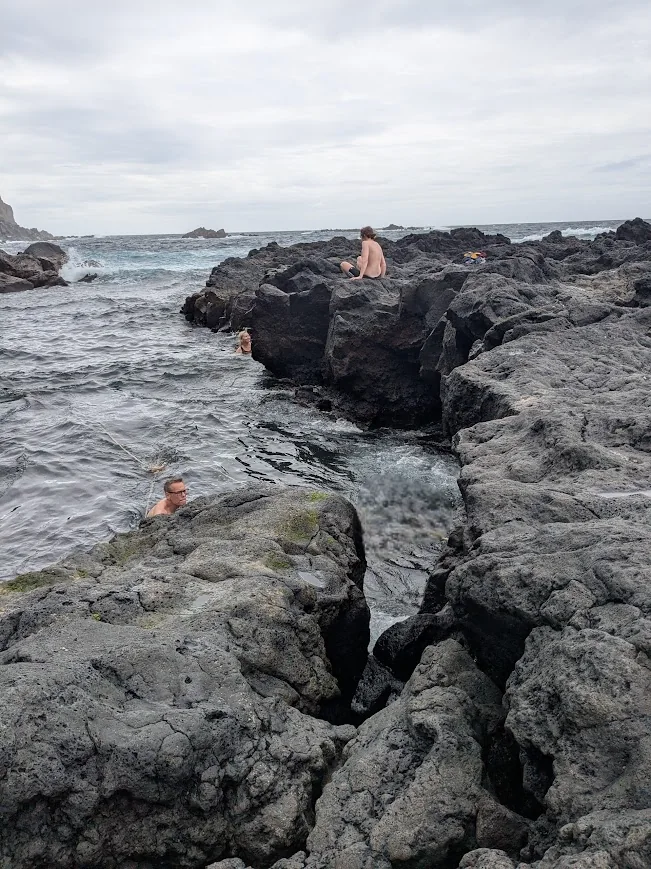Swimmers in volcanic hot springs at Ponta da Ferraria, São Miguel, Azores