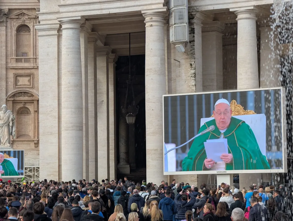 Crowd at St. Peter's Square watching Pope Francis say Mass on a large outdoor screen, February 2025
