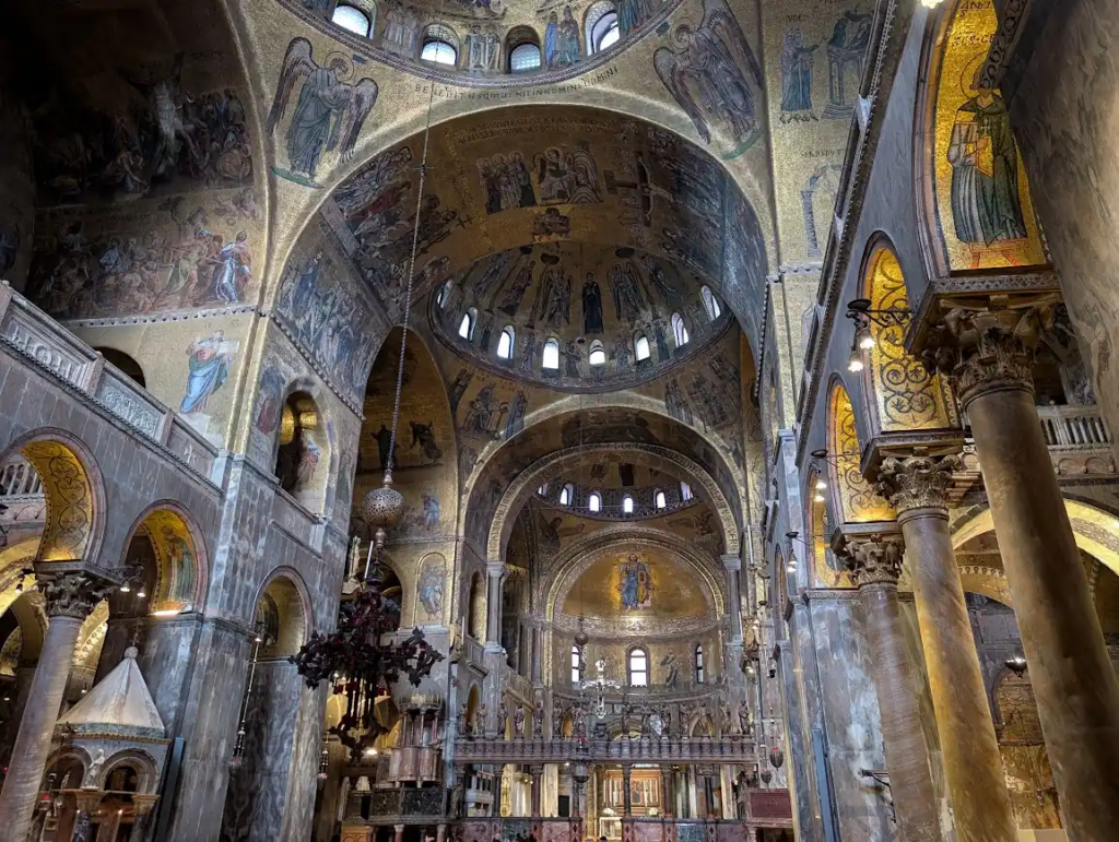 St. Mark's Basilica interior in Venice showing Byzantine mosaics covering the arched ceilings and domes