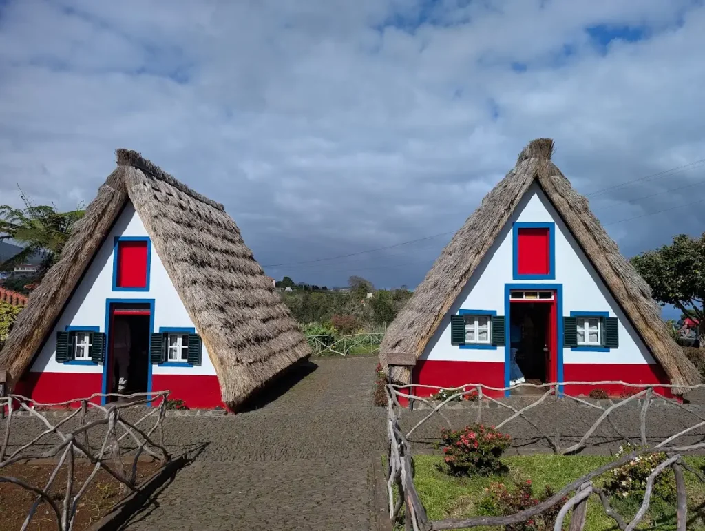 Two traditional A-frame thatched houses with red, white and blue paintwork, Santana, Madeira