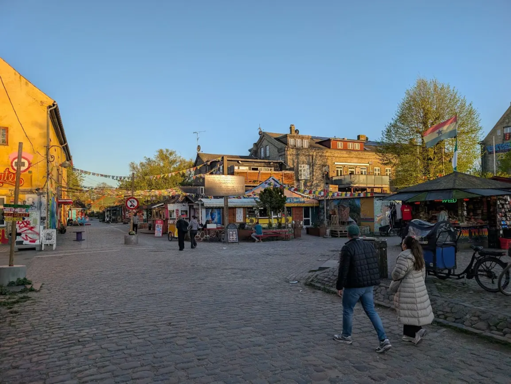 Freetown Christiania in Copenhagen – market stalls, cobblestone square, flags and murals