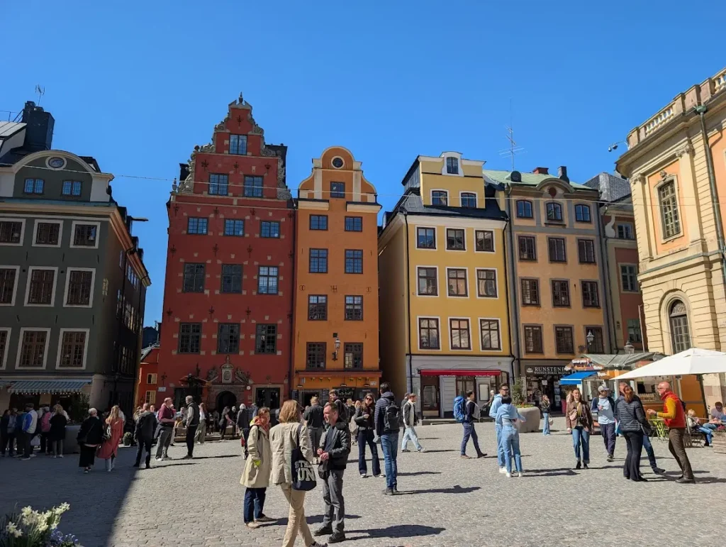 Colorful medieval buildings and crowds at Stortorget square in Stockholm's Gamla Stan old town