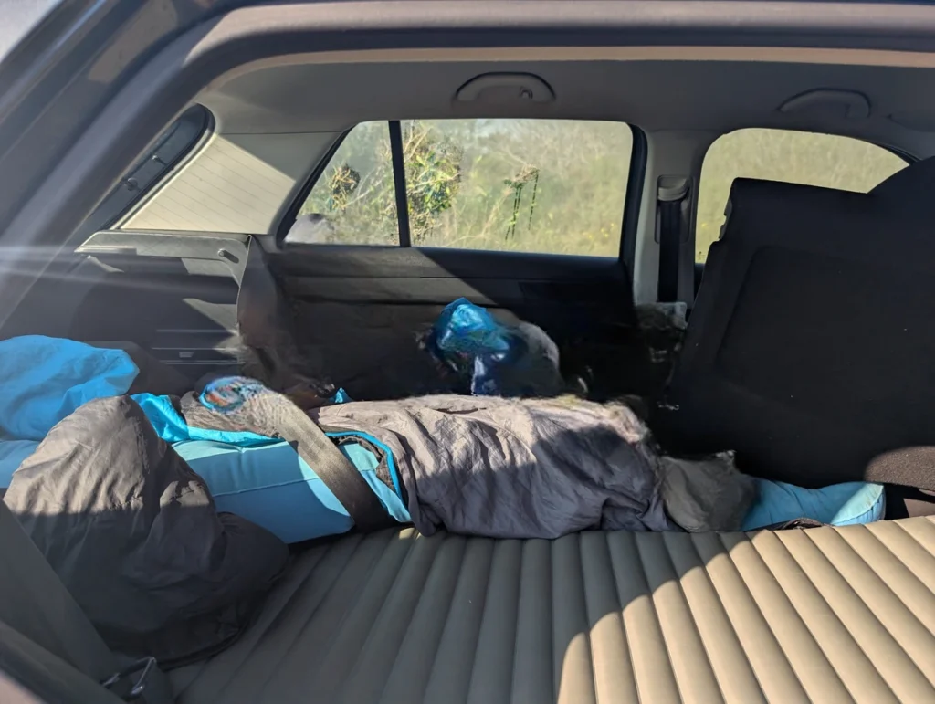 Inflatable Therm-a-Rest sleeping mat laid out flat in car boot on folded rear seats