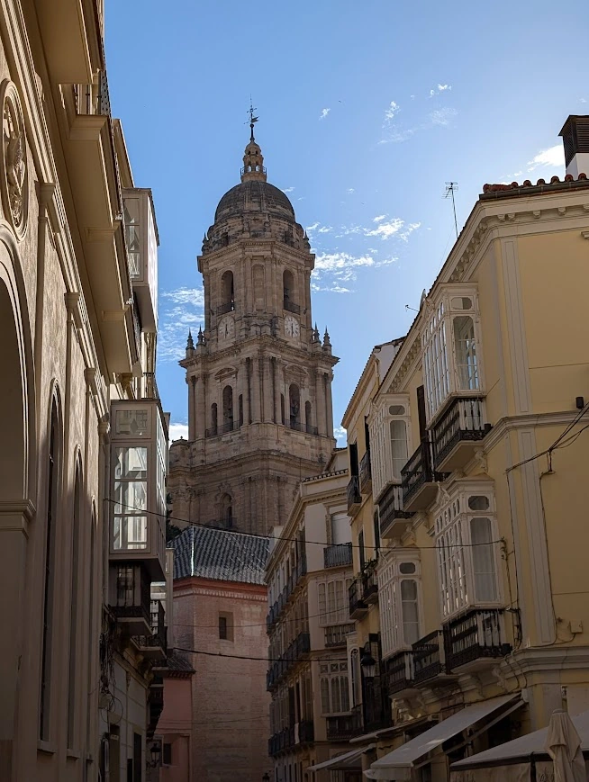 Málaga Cathedral tower visible between narrow old town streets
