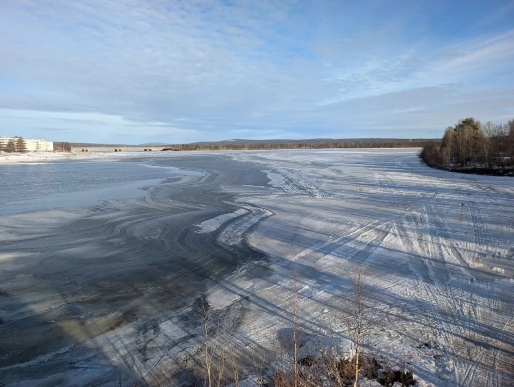 Frozen Kemijoki river in Rovaniemi, Finland, March 2026, with tyre tracks on the ice