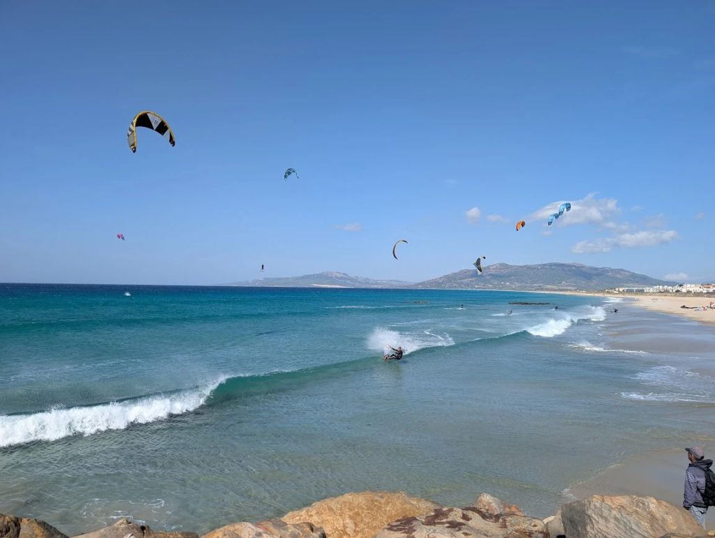 Kitesurfers on the Atlantic coast at Tarifa, southern tip of Spain, with Morocco visible in distance