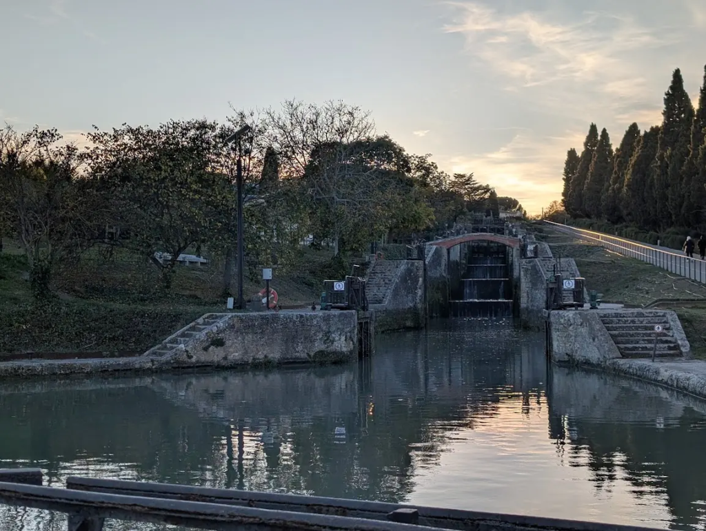 Fonseranes locks on the Canal du Midi near Béziers at sunset, with stone lock chambers and steps beside the water
