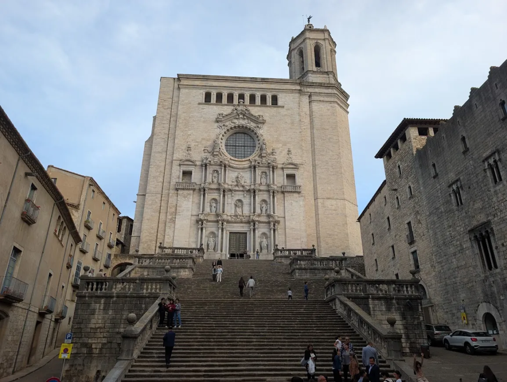 Girona Cathedral seen from the bottom of its wide stone staircase, Gothic facade with a large rose window