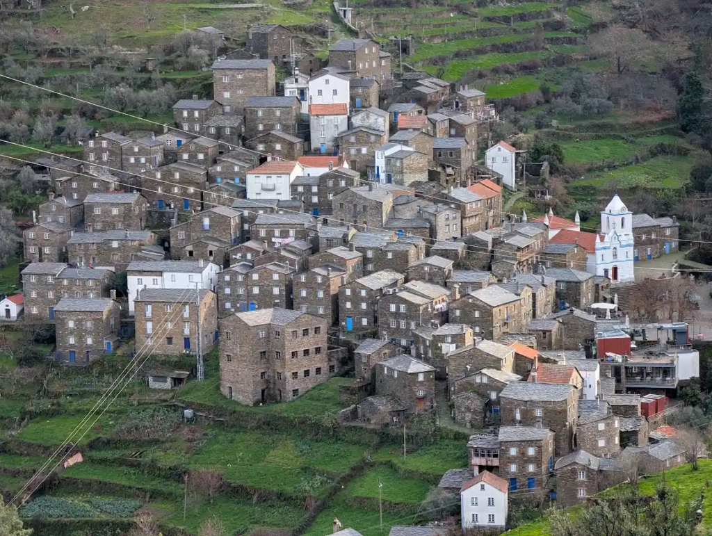 Terraced stone houses of the schist village of Piódão on a green hillside in central Portugal