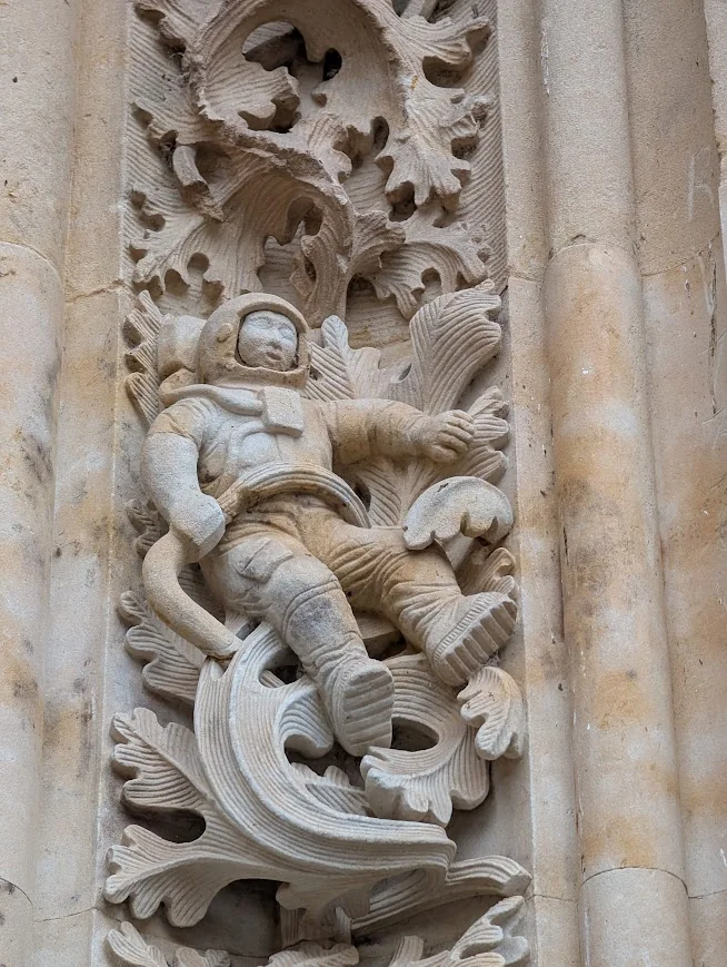 Carved stone astronaut among leaves on the facade of the New Cathedral in Salamanca, Spain