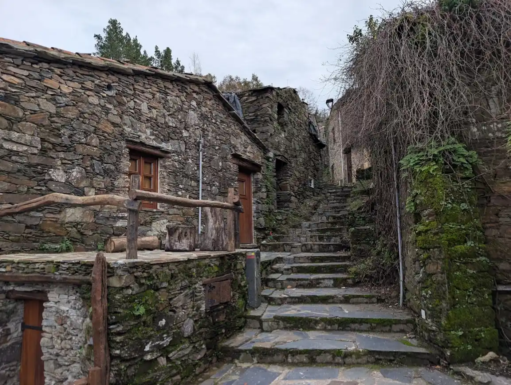 Stone steps between dark schist houses in a mountain village in Serra da Lousã, Portugal