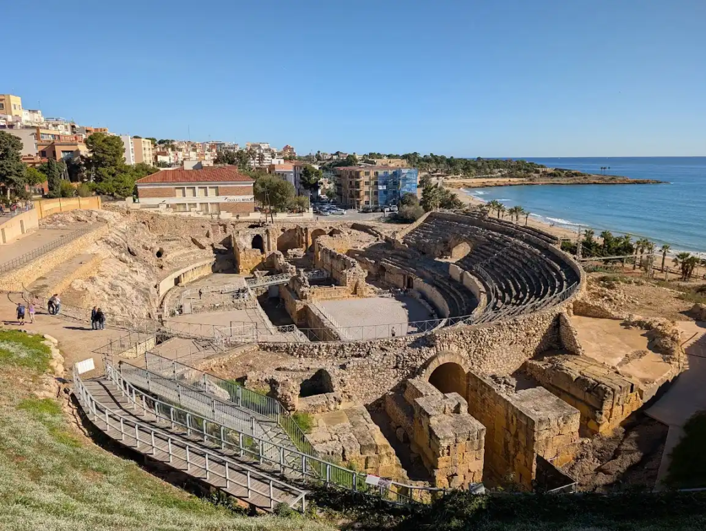 Roman amphitheater ruins in Tarragona overlooking the Mediterranean coast and beach, stone terraces intact