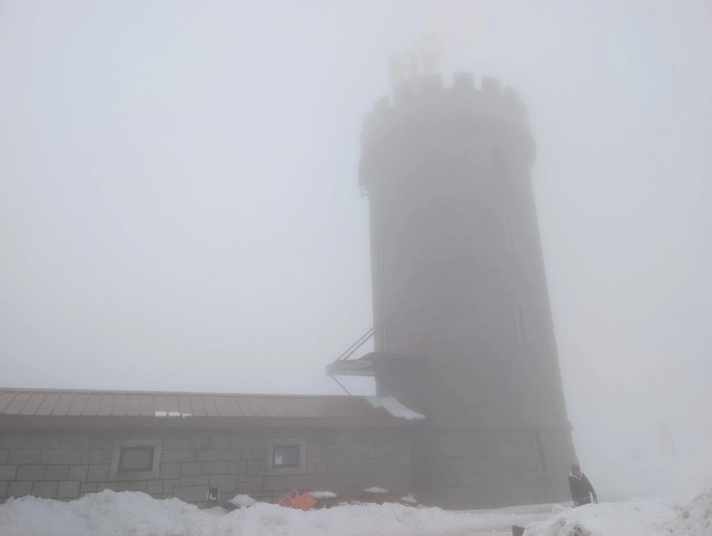Stone tower at Torre, the highest point of mainland Portugal in Serra da Estrela, wrapped in fog and snow