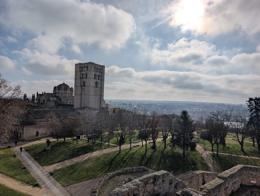 Zamora Cathedral bell tower and dome seen from the castle grounds in Spain, with the city and a cloudy sky behind